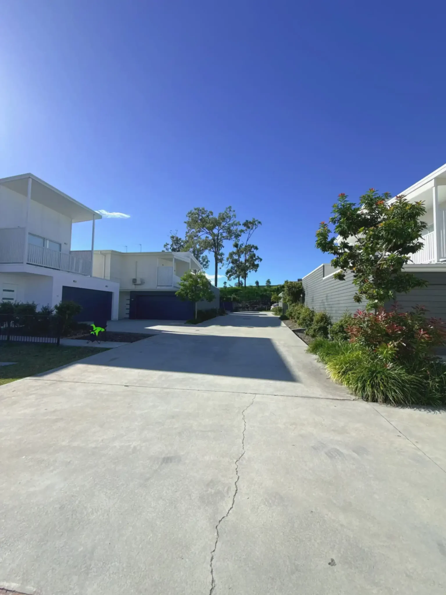 Shared driveway through a landscaped townhouse complex with double garages